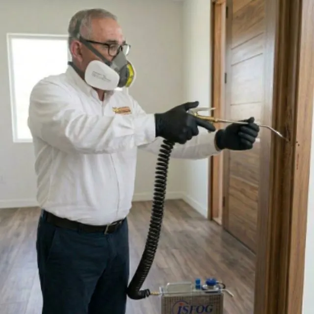Técnico aplicando tratamiento de fumigación de termitas con equipo especializado en Mexicali